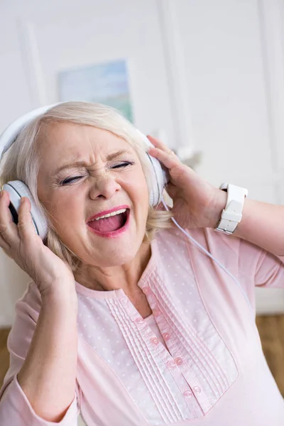 Femme âgée dans les écouteurs — Photo de stock