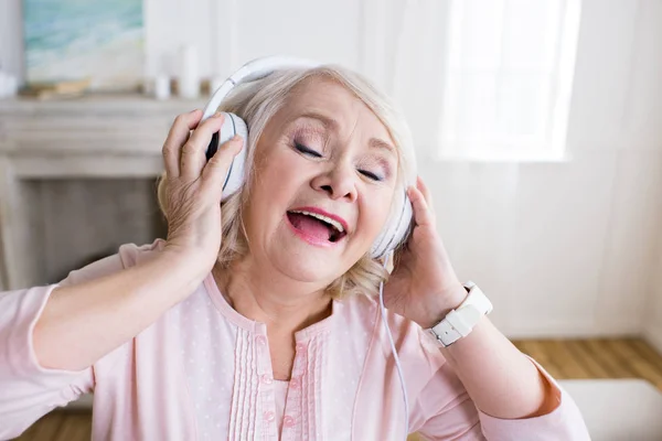 Femme âgée dans les écouteurs — Stock Photo