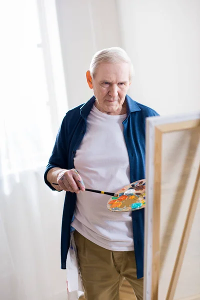 Senior man drawing picture — Stock Photo