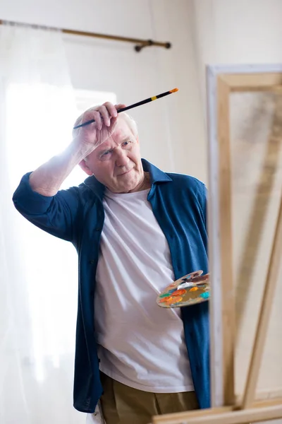 Senior man drawing picture — Stock Photo