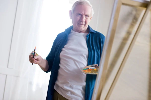 Senior man drawing picture — Stock Photo