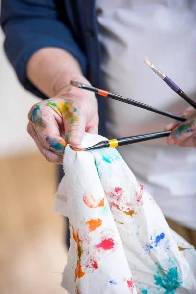 Man cleaning paint brushes — Stock Photo