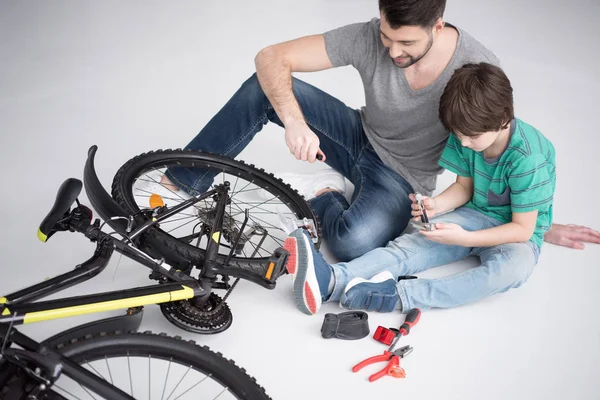 Padre e figlio riparano biciclette — Foto stock