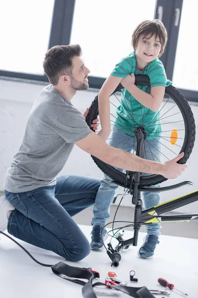 Pai e filho reparando bicicleta — Fotografia de Stock