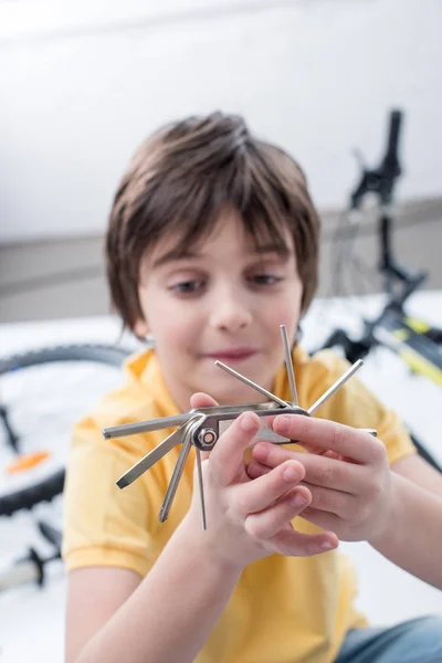 Boy with bicycle multi tool — Stock Photo