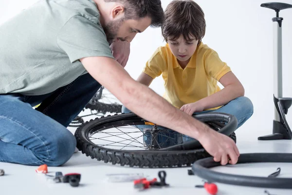 Son and father repairing bicycle — Stock Photo