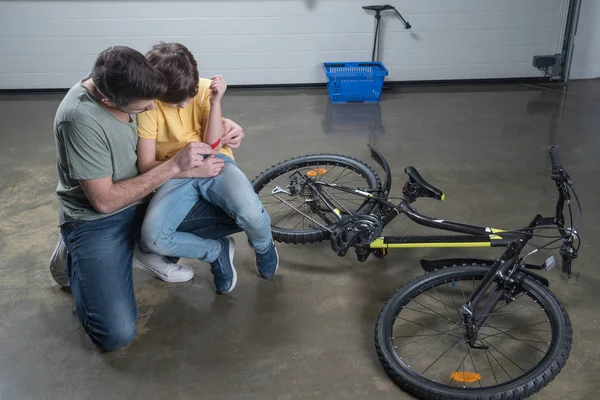 Father putting patch on son — Stock Photo