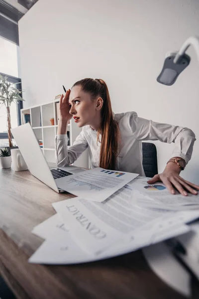 Stressed businesswoman with laptop — Stock Photo