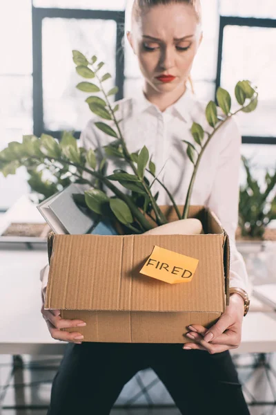 Fired businesswoman holding box — Stock Photo