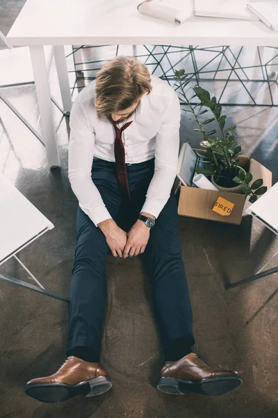 Triste trabajador despedido llevando sus suministros de oficina con él - foto de stock