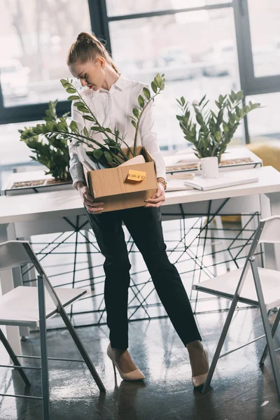 Fired businesswoman holding box — Stock Photo