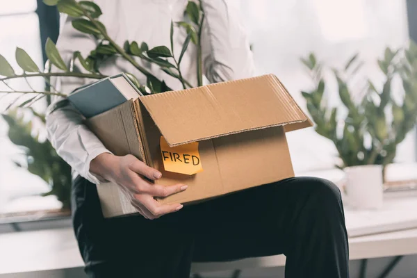 Fired businesswoman holding box — Stock Photo