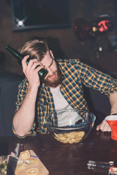Mann mit Kopfschmerzen hält Bier in der Hand — Stockfoto