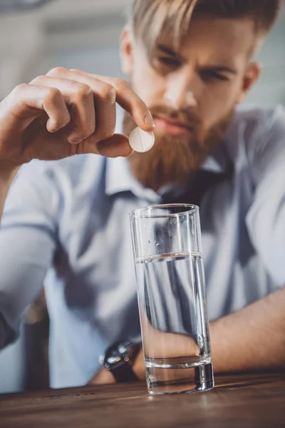 Uomo con postumi di sbornia con medicinali — Foto stock