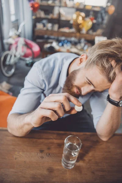 Hombre con resaca con medicamentos - foto de stock