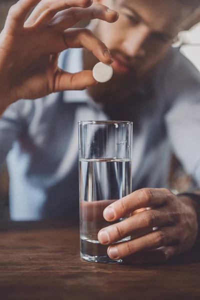 Hombre con resaca con medicamentos - foto de stock