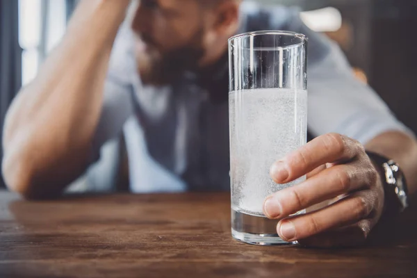 Hombre con resaca con medicamentos - foto de stock