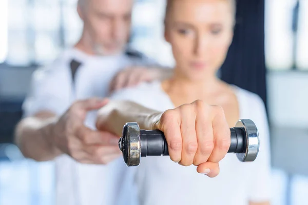 Sportswoman and senior trainer with dumbbell — Stock Photo