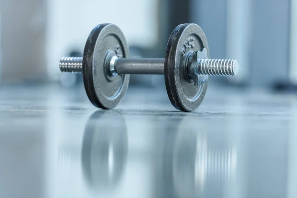 Metallic dumbbell on floor — Stock Photo