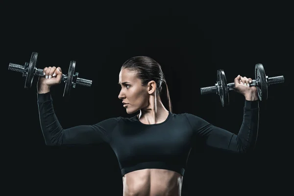 Sportswoman training with dumbbells — Stock Photo