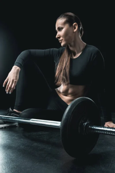 Sportswoman resting at barbell — Stock Photo