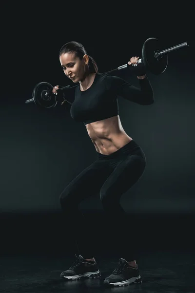 Sportswoman training with barbell — Stock Photo