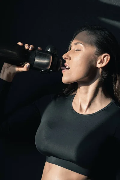 Sportswoman holding bottle — Stock Photo