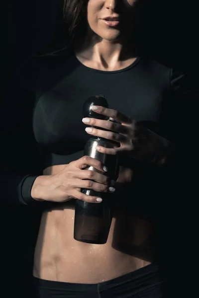 Sportswoman holding bottle — Stock Photo