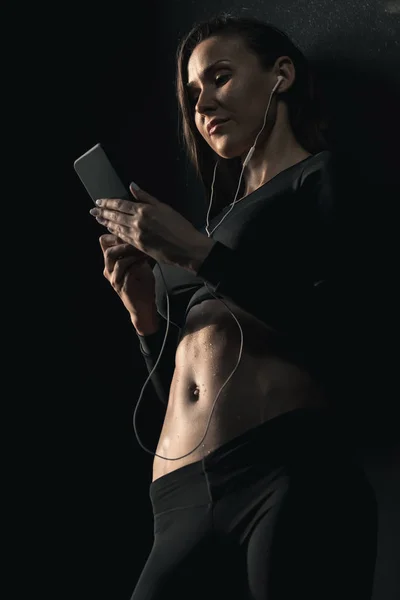 Femme sportive utilisant un smartphone — Photo de stock