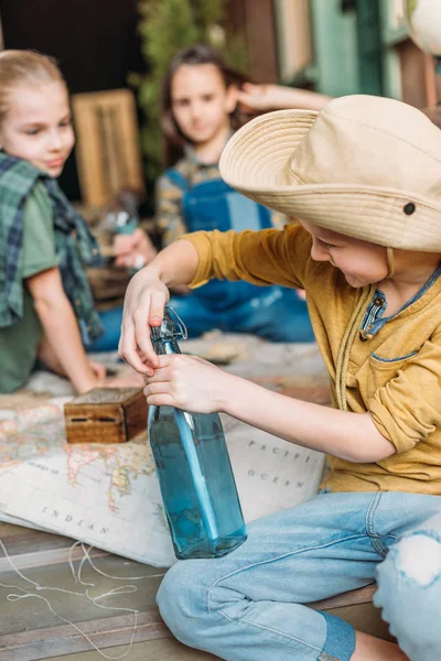 Boy putting message in a bottle — Stock Photo