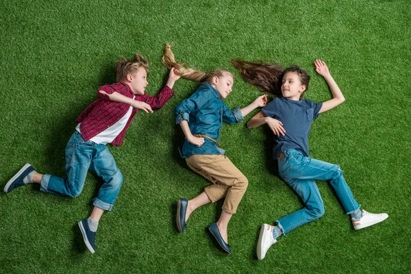 Enfants couchés sur l'herbe — Photo de stock