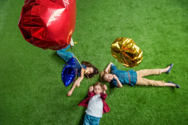 Enfants couchés sur l'herbe — Photo de stock