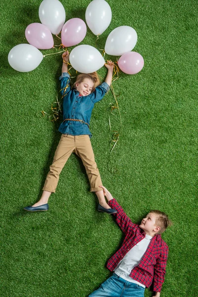 Chico holding chica con globos - foto de stock