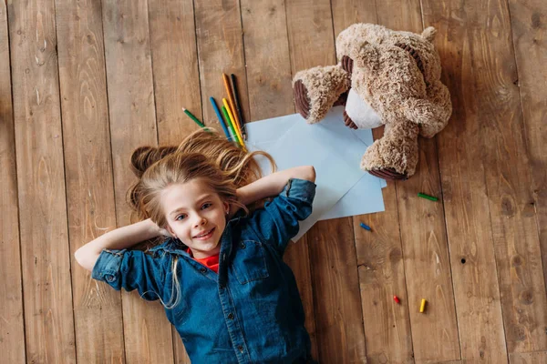 Menina com brinquedo e lápis — Fotografia de Stock