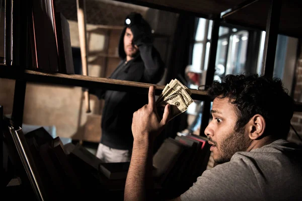 Scared man hiding from burglar — Stock Photo