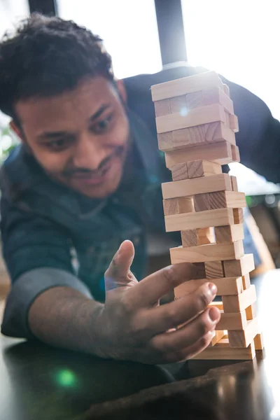 Hombre jugando jenga juego - foto de stock