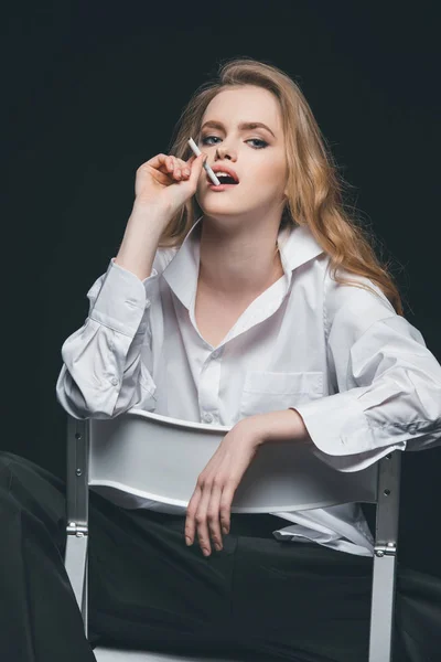 Woman smoking cigarette on chair — Stock Photo