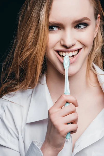 Mujer en camisa masculina cepillarse los dientes - foto de stock