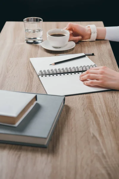 Woman sitting at table with cup of coffee — Stock Photo