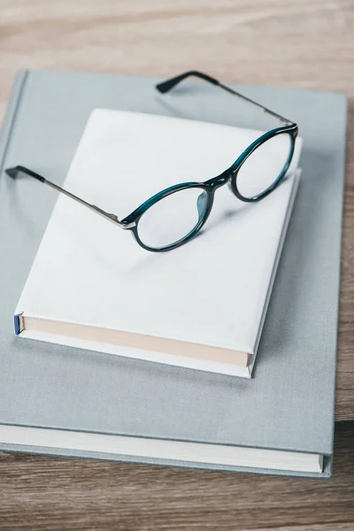 Dos libros y anteojos en la mesa - foto de stock