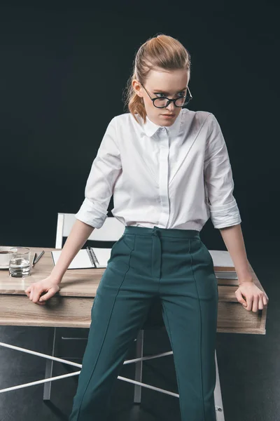 Woman in eyeglasses leaning on table — Stock Photo