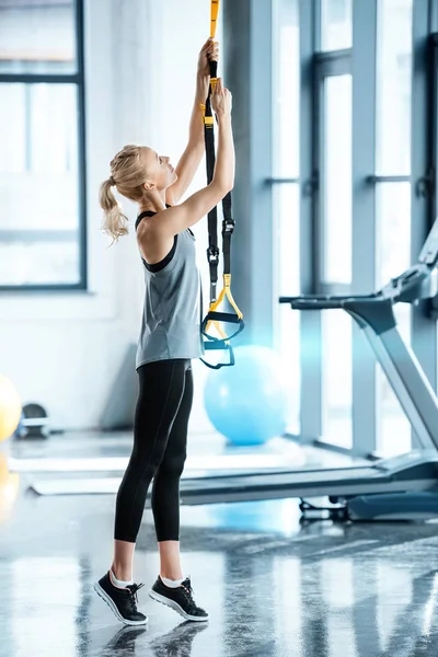 Femme de fitness béatifique se reposant pendant l'entraînement avec des sangles de fitness trx — Photo de stock