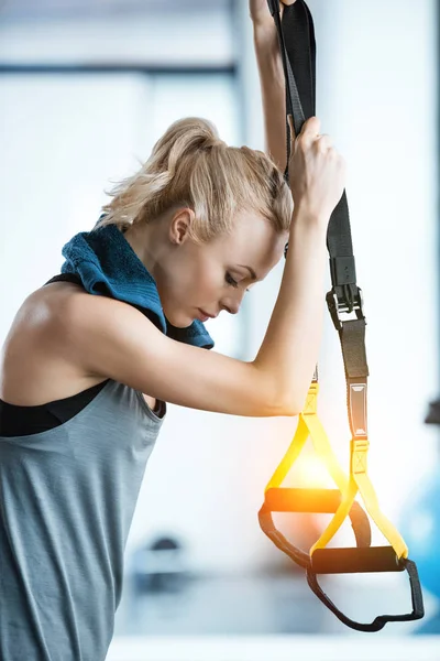 Schöne Fitness-Frau ruht sich beim Training mit trx-Fitnessbändern aus — Stockfoto