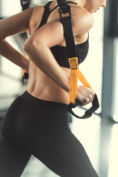 Фитнес-женщина блондинка с фитнес-лямками trx — стоковое фото