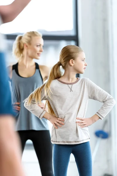 Junge Frau und süßes Mädchen trainieren mit Trainer im Fitnessstudio — Stockfoto