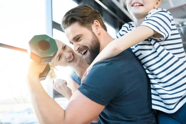 Feliz joven y chica buscando chico entrenamiento con mancuerna — Stock Photo