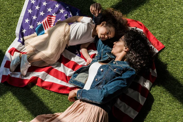 Mujer con hija en bandera americana - foto de stock
