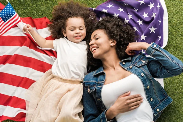 Жінка з дочкою на американському прапорі — стокове фото