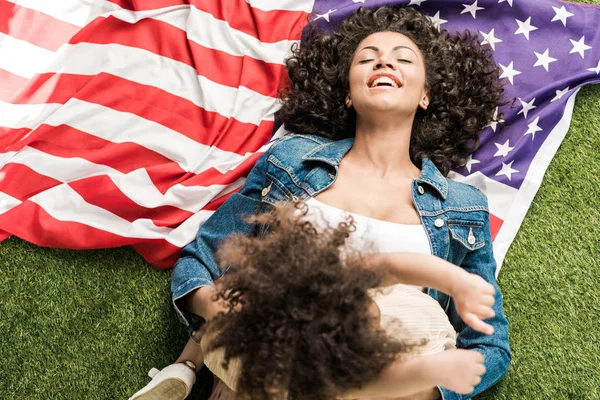 Mujer con hija en bandera americana - foto de stock