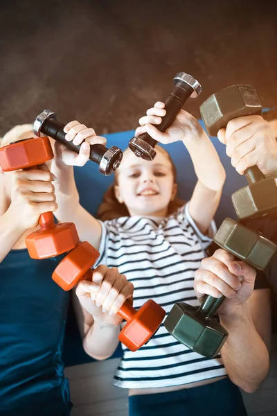 Happy family exercising with dumbbells at fitness studio,  dumbbells in heart shape — Stock Photo